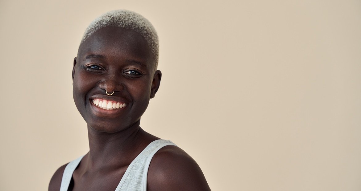 Jovem negra sorrindo alegremente, um exemplo do cabelo para waves ou waves 360